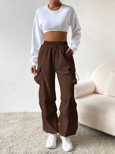 Deep brown cargo pants paired with a white cropped sweatshirt and sneakers for a casual look