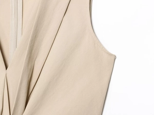 Detailed macro view of khaki midi dress shoulder seams and fine fabric texture