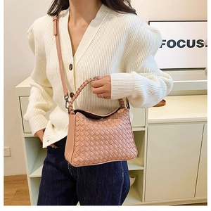 Detail of pink hand-woven leather bag texture with thick top handle and slim strap