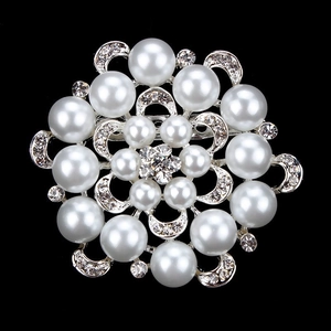 Close-up of a silver floral brooch with radiant white pearls and sparkling rhinestones