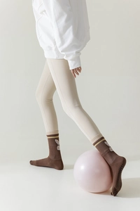 Detail view of brown five-finger yoga socks with bunny pattern and non-slip sole grips