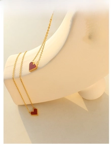 Detail of red heart pendant necklace with gold chain and beaded edge craftsmanship