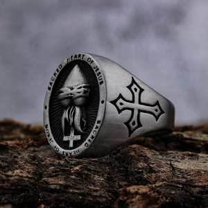 Vintage stainless steel Sacred Heart of Jesus and cross ring on rustic bark background