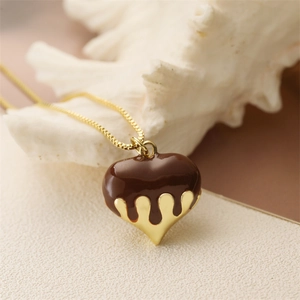 Dettaglio ravvicinato del ciondolo a cuore dorato con effetto smalto cioccolato fuso