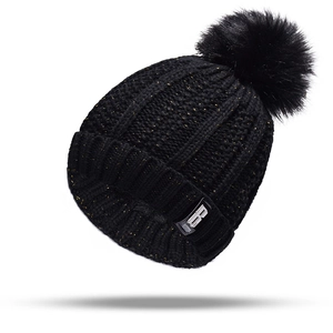 Detail of black knit beanie with shimmering gold metallic yarn and faux fur pompom
