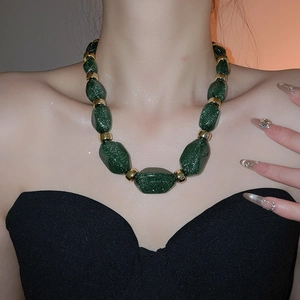 Close-up of chunky dark green glitter acrylic beads on a short choker necklace