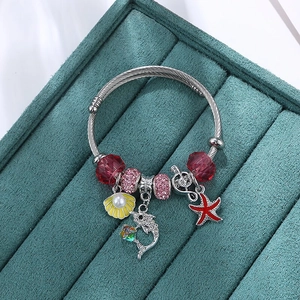 Detail of silver cable bracelet with colorful dolphin, seashell and pearl charms