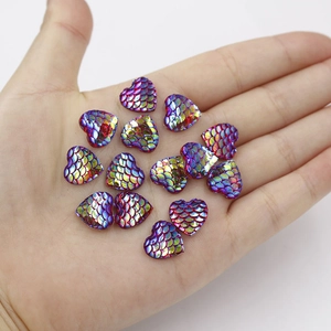 Iridescent purple heart-shaped resin scales with mermaid texture on hand display