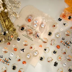 Detail view of Halloween nail stickers featuring gold-trimmed pumpkin and black cat motifs