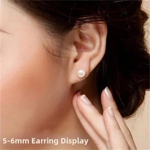 Close-up of 5-6mm white freshwater pearl stud earrings on model for size reference