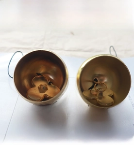 Détail d'une cloche en cuivre pur avec battant en trèfle et finition dorée mate