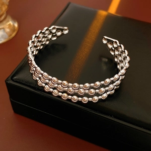 Dettaglio del bracciale aperto in argento a tre strati su un portagioie in pelle nera