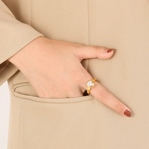 Bague chic en acier titane doré avec pierre de zircon blanc sur main de femme