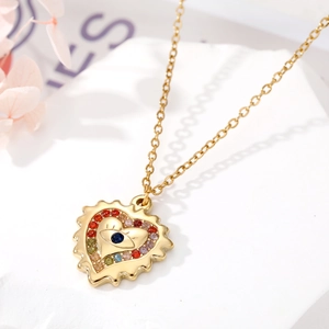 Gros plan d'un collier cœur doré avec pendentif œil bleu et zircons multicolores