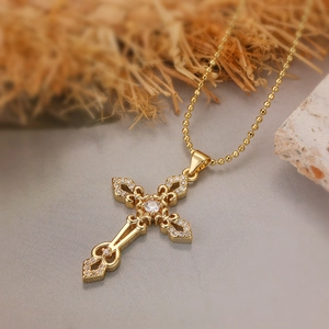 Exquisite gold-plated cross pendant necklace with white zircons on a rustic grey stone