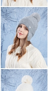 Detailed knit texture of a grey winter hat with a soft faux fur pom-pom and ear flaps