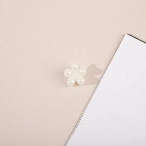 Close-up of a white five-petal flower pearl hair clip with smooth glossy finish