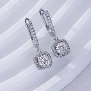Macro shot of silver square halo earrings with sparkling cubic zirconia on white tray