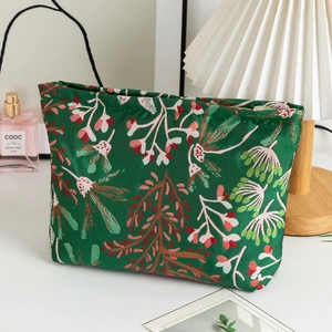 Détail de trousse de maquillage fleurie verte en tissu tissé avec fermeture éclair en métal