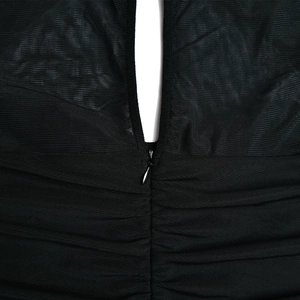 Detail des schwarzen Netzkleides mit eleganter Faltenstruktur und verdecktem Reißverschluss