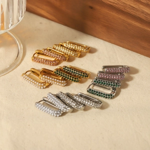 Luxe U-shaped stainless steel earrings with colorful zircon and pearls on beige cloth