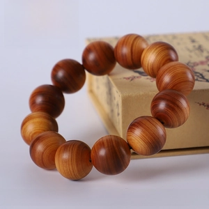 Macro detail of high-oil Thuja wood beads showing natural wavy texture on 20mm bracelet