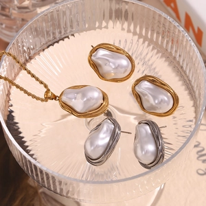 Close-up of Baroque pearl necklaces and earrings in gold and silver set in glassware