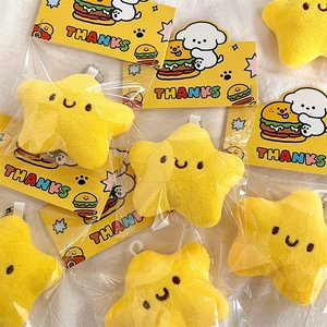 Primer plano de llaveros de estrellas de peluche amarillo con cadenas y envoltorio