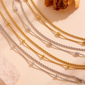 Detail of double-layer stainless steel twist and snake chains with gold bead accents