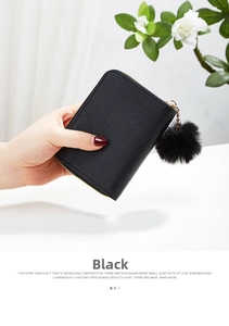 Detailed view of mini black PU leather wallet with fluffy pompom and gold zipper