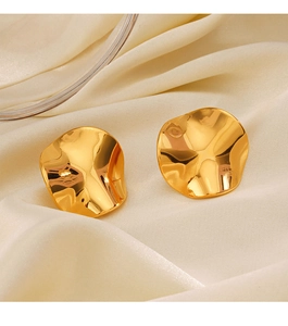 Detailed close-up of irregular 18K gold plated earrings resting on beige silk fabric