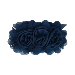 Detail of dark blue chiffon rose hair clips with layered petals on a white background