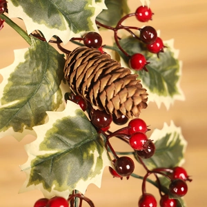 Christmas wreath decoration with pine cones red berries and white-edged leaves on wood background
