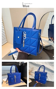Detail of blue geometric quilted PU leather tote bag with hanging coin purse and gold pendant