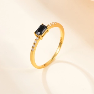 Detailed macro view of S925 sterling silver gold ring with black gemstone and zircons