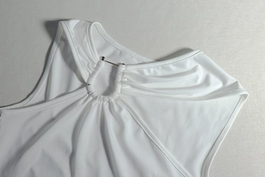 Detailed close-up of the white halter neck dress featuring a sleek metal ring buckle