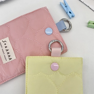 Close-up of quilted heart pattern card holder with metal ring and snap button closure