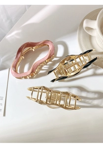 Detailed overhead view of premium metal hair claws with enamel accents and cutout designs