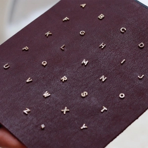 Close-up of complete A-Z set of gold-plated letter stud earrings with inlaid diamonds