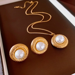Nahaufnahme von Vintage-Goldschmuck-Set mit weißen Perlen in einer Schmuckschatulle