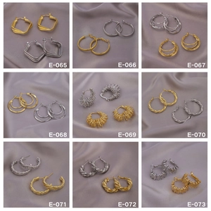 Macro display of nine luxury geometric metal hoop earrings in gold and silver finishes