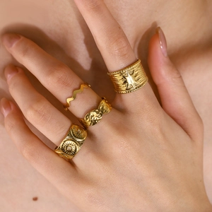 Set of four gold stainless steel rings with sunflower and star patterns for women