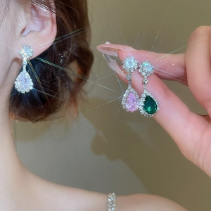 Detail of tear-drop zircon earrings in pink, white, and green with a sparkling finish