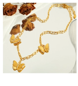 Detail of elegant gold double-layered necklace with three shimmering zircon butterfly pendants
