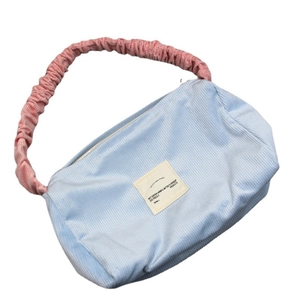 Blue corduroy underarm bag with pink ruffled shoulder strap and square fabric patch