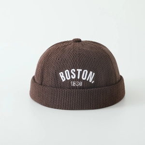 Gros plan détaillé du bonnet miki en tricot marron foncé avec broderie Boston blanche
