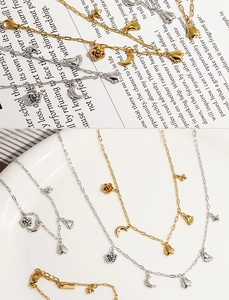Detailed close-up of multilayer stainless steel necklaces with moon and floral pendants