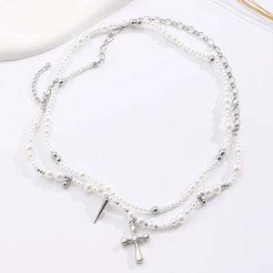 Detail shot of double-layer pearl and metal bead necklace with a cross pendant