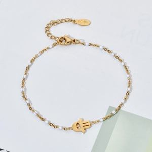Detail of gold stainless steel Hamsa hand bracelet with white beads and S-STEEL hallmark