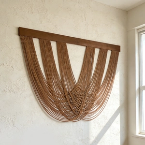 Modern woven cotton rope wall hanging with dark wood rod and brown U-shaped layers